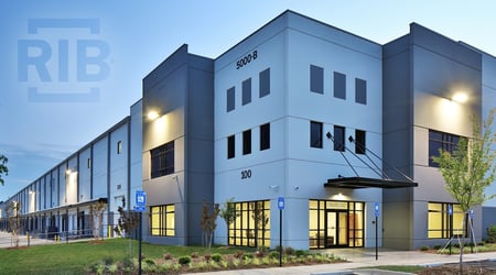 Commercial building at dusk with lights on.